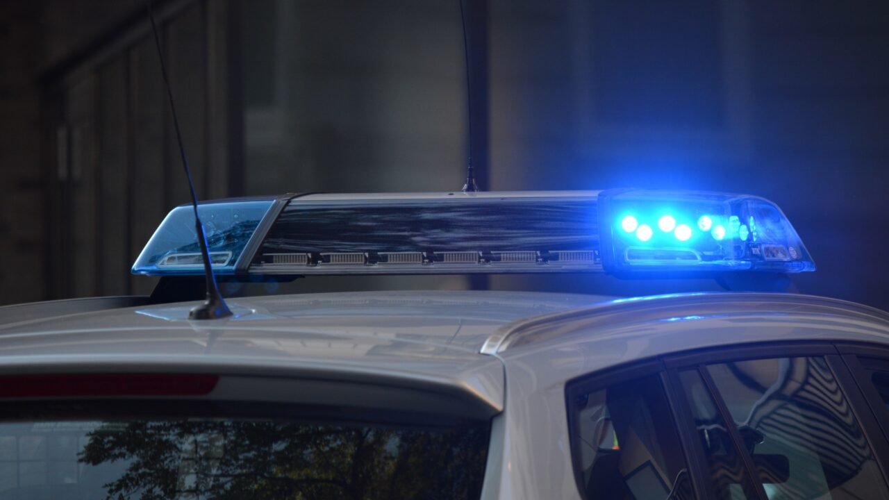 Close-up of a police vehicle roof light bar flashing blue at night